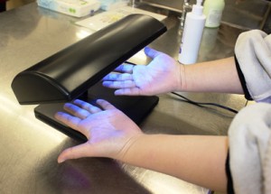 「手洗いチェッカー」は、手に専用のローションをつけて、手洗い後に専用ライトを当てると、洗い残し部分が光るという仕組みです